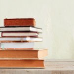 Old books of stacked on wooden floor.